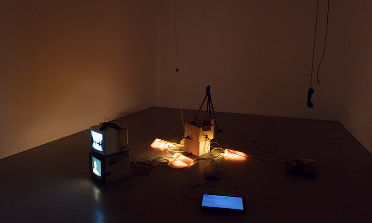 Lights and monitors on the floor of a New Genres installation space