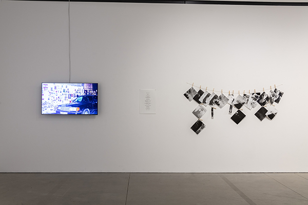 A monitor and photographs on gallery walls