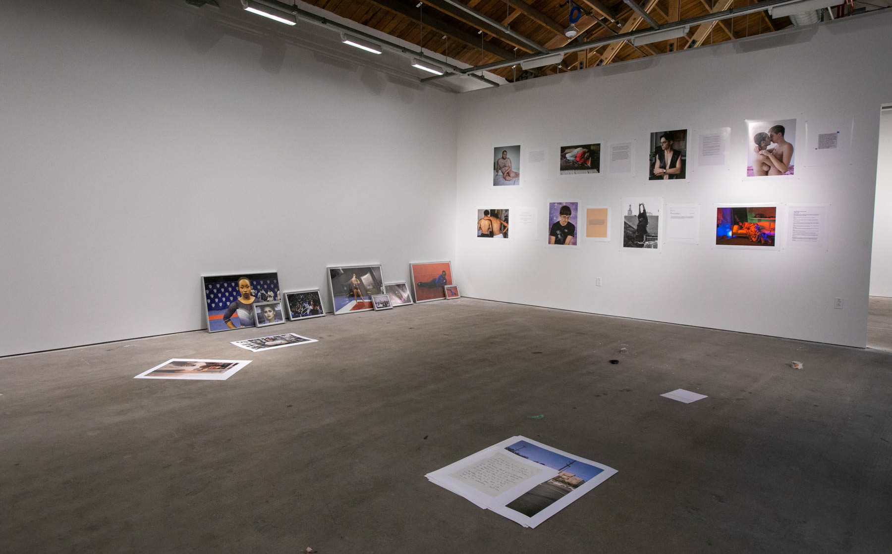 Photographs installed on the floor and walls of a graduate studio
