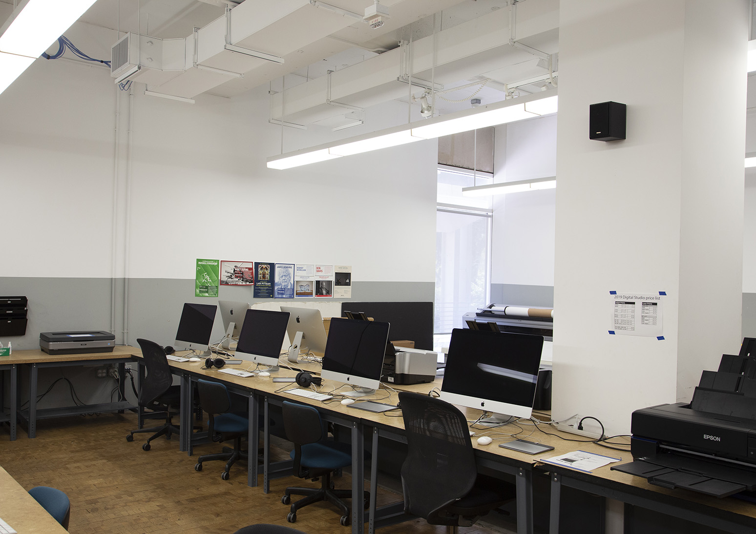 Computers, a printer and a scanner on tables in the digital studio