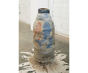 An off-white ceramic vessel with blue and red figures and text
