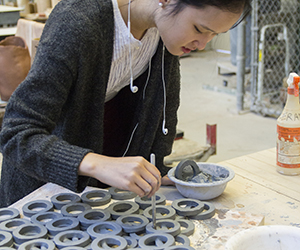 A student works on a ceramic piece