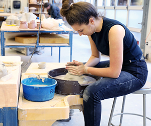 A student works on a throwing wheel