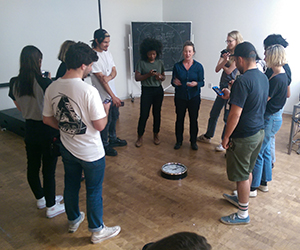 Students and faculty stand in a circle during a class discussion