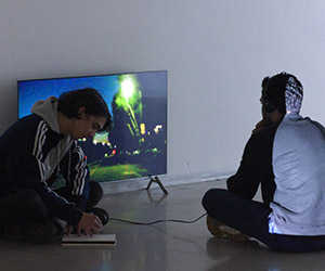 Students in front of a television monitor on the floor