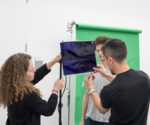 Students and faculty add a blue gel to a studio light