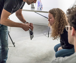 An instructor shows features of a lens to students