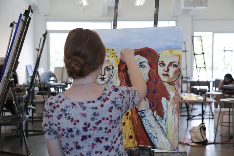 student painting at an easel